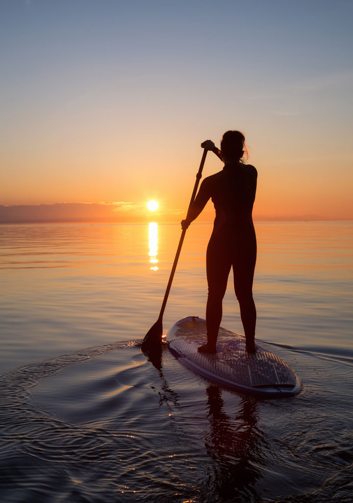 personne sur un paddle au coucher du soleil