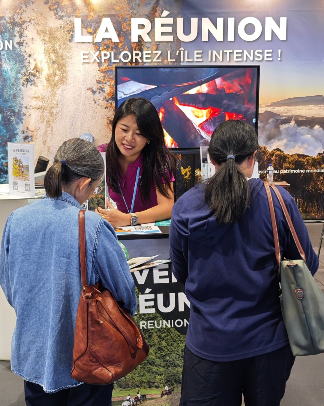 Li, Conseillère en séjour à la FRT en train d'accueillir 2 personnes sur le stand de La Réunion au salon VEEZIT