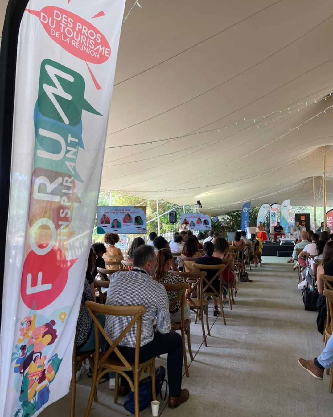 Participants assis de dos dans le lieux extérieur servant aux conférences dans le jardin d'Eden