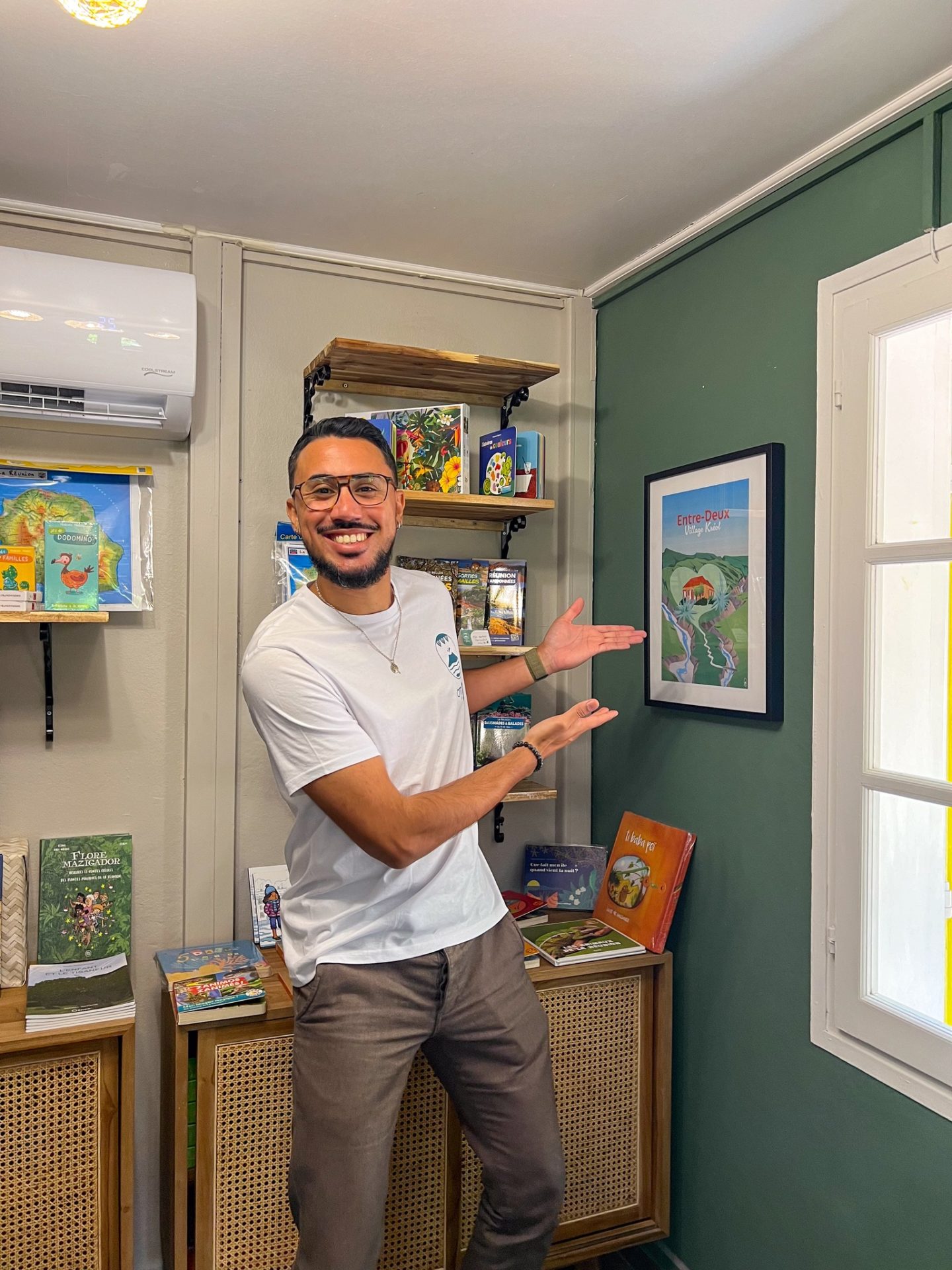 Christophe (OTI SUD) pose devant le poster qu'il a réalisé pour ajouter une touche créole à la deco de la "kaz tourist'".